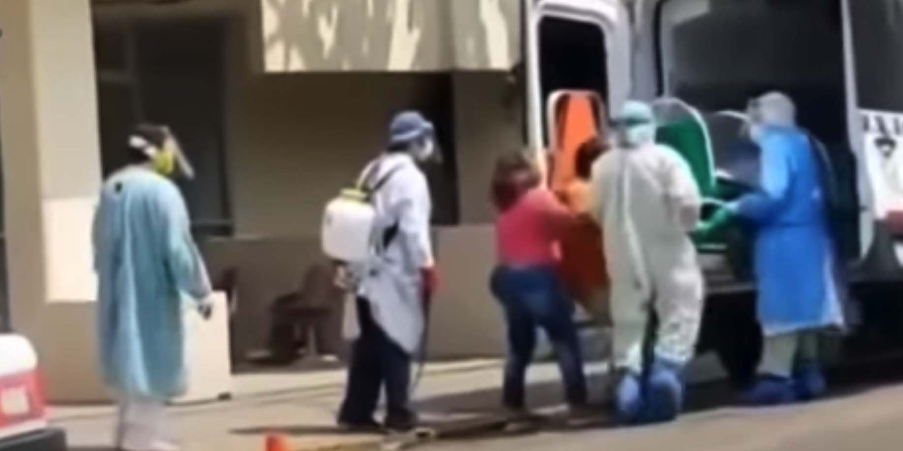 Familia de mujer con síntomas de Covid-19 forcejea con camilleros