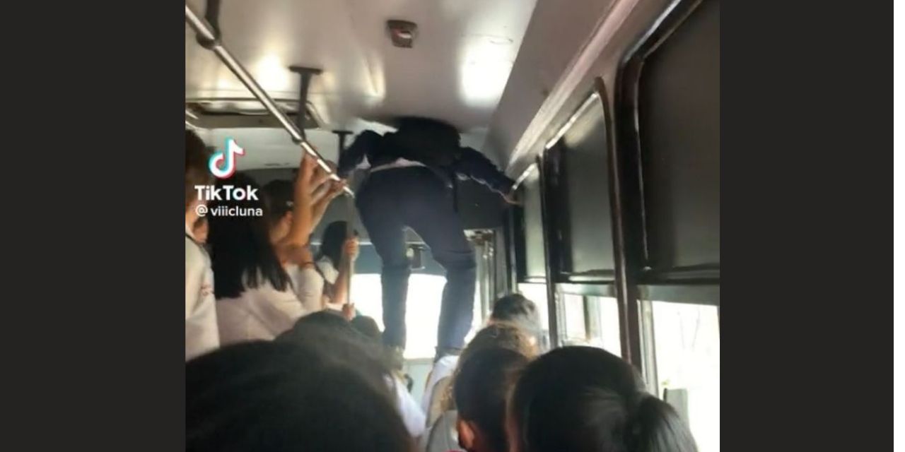 Estudiante camina sobre pasajeros de un autobús para bajar y llegar a clases a tiempo