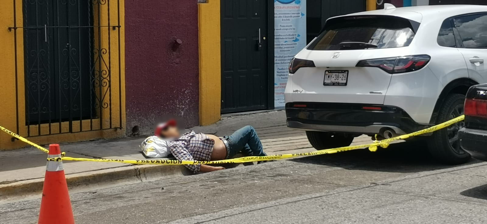 HOMBRE TIRADO EN LA BANQUETA 