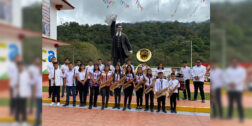 Una banda musical de Huautla posa frente a la estatua de RFM en Eloxochitlán.