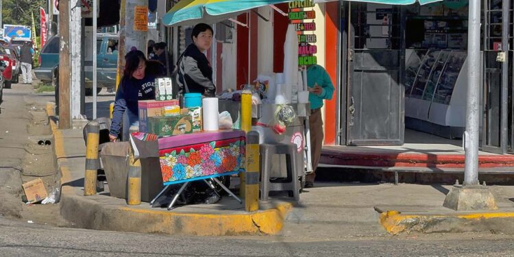 Una de las esquinas más transitadas de la ciudad sitiada por uno de los puestos ambulantes que, incluso, invade una de las rampas para discapacitados.