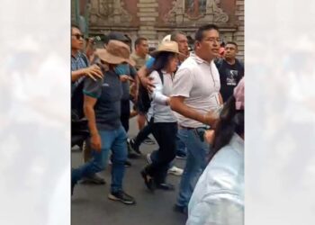 Foto: internet // Yenni Pérez Martínez, dirigente de la Sección 22, fue escoltada ante los abucheos de la base, después de informar sobre los acuerdos en la mesa de negociación en Gobernación.