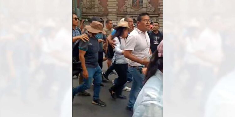 Foto: internet // Yenni Pérez Martínez, dirigente de la Sección 22, fue escoltada ante los abucheos de la base, después de informar sobre los acuerdos en la mesa de negociación en Gobernación.