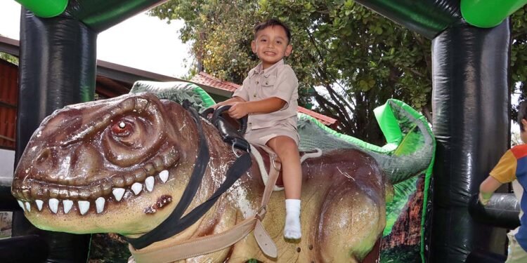 Fotos: cortesía // Luis David arriba del ‘toro mecánico’ con forma de dinosaurio.