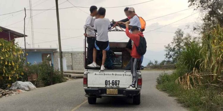 Los usuarios prefieren viajar colgados en los carros que transportan pasaje.