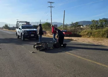 Elementos voluntarios de la Cruz Roja atienden a una motociclista lesionada tras colisionar con una camioneta en Miahuatlán.