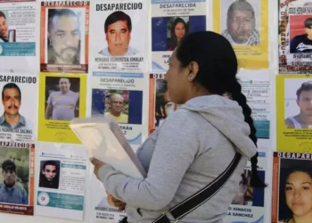 Foto: Ivonne Mateo // Familiares rehabilitan la mampara con imágenes de desaparecidos que ha sido vandalizada o estropeada por ambulantes y autoridades.