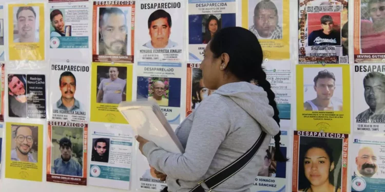 Foto: Ivonne Mateo // Familiares rehabilitan la mampara con imágenes de desaparecidos que ha sido vandalizada o estropeada por ambulantes y autoridades.