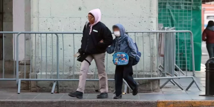 Foto: Adrián Gaytán // Madres y padres de familia aceleraron el paso hacia las escuelas mientras evidenciaban el sentir del intenso frío de la mañana.