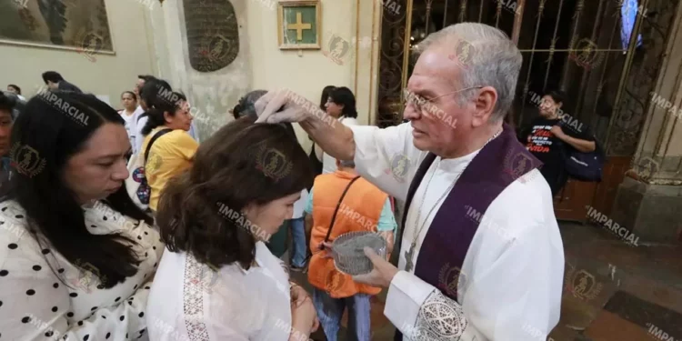 Foto: Adrián Gaytán // Uno a uno, incluso bebés, eran marcados en sus frentes o cabeza con la ceniza bendecida para tal fin.
