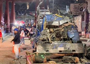 Un camión tipo plataforma que transportaba rollos de madera se impactó contra una vivienda.