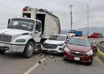 El camión compactador Freightliner y los dos vehículos particulares quedaron varados bloqueando el carril con dirección poniente-oriente sobre la Carretera 190.