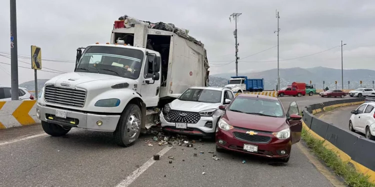 El camión compactador Freightliner y los dos vehículos particulares quedaron varados bloqueando el carril con dirección poniente-oriente sobre la Carretera 190.