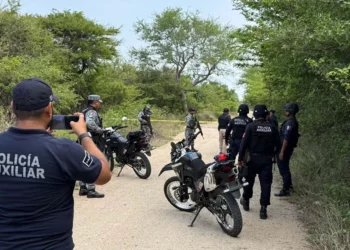 Elementos de la Policía Municipal y peritos de la Fiscalía de Género resguardan el camino de terracería hacia el paraje Santa Cruz tras el hallazgo del cuerpo de la mujer víctima de violencia.
