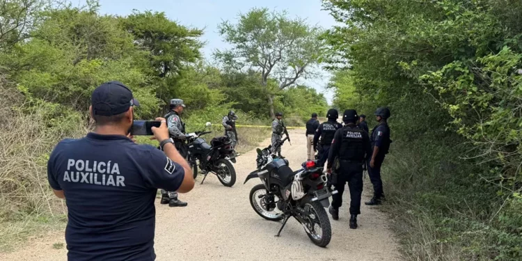 Elementos de la Policía Municipal y peritos de la Fiscalía de Género resguardan el camino de terracería hacia el paraje Santa Cruz tras el hallazgo del cuerpo de la mujer víctima de violencia.