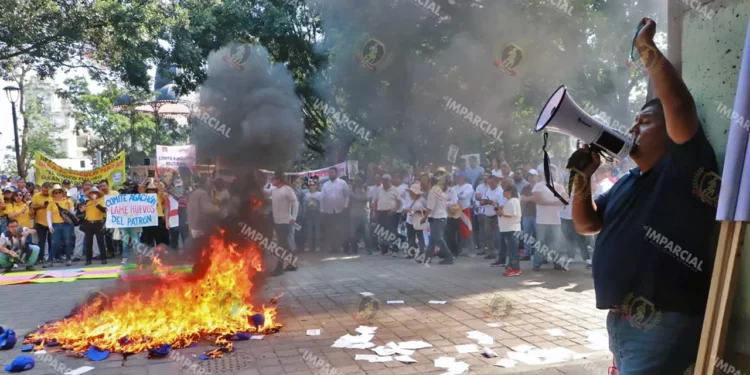 Foto: Adrián Gaytán // Burócratas queman las gorras entregadas por la dirigencia sindical para la movilización por el Día del Trabajo.