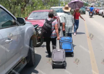 Fotos: Adrián Gaytán // Pasajeros aéreos obligados a caminar por el bloqueo magisterial.