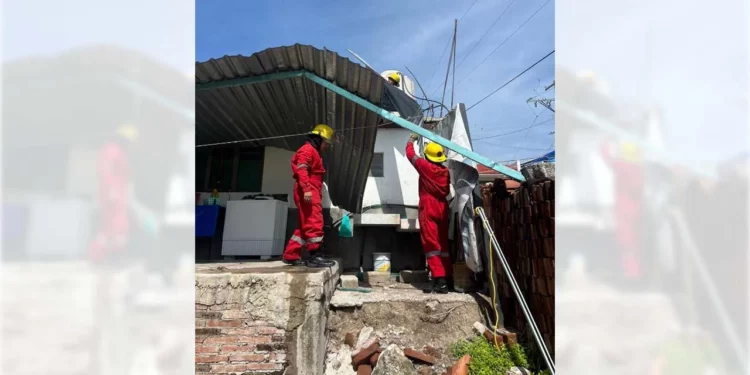 Elementos de Bomberos y Protección Civil laboran en la remoción de las láminas colapsadas.
