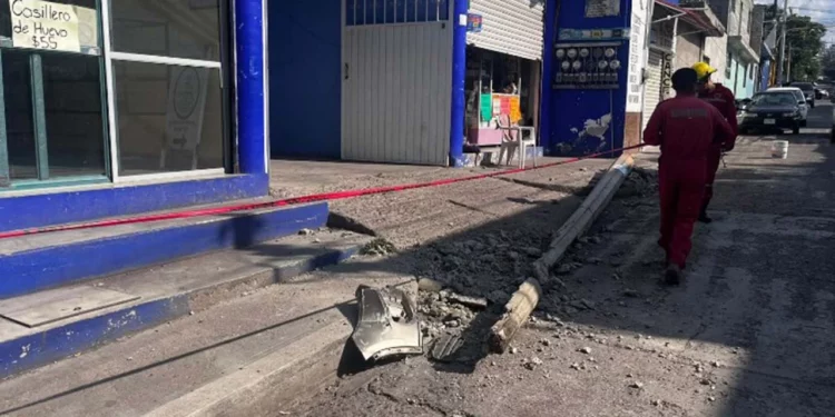 El poste de concreto de la CFE quedó partido y obstruyendo la banqueta tras el impacto.