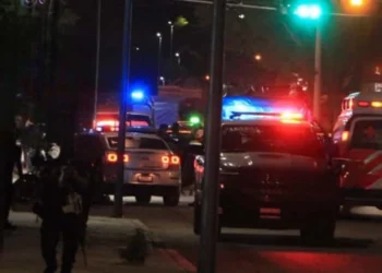 Peritos de la Fiscalía General de Oaxaca recolectan decenas de casquillos percutidos sobre el asfalto tras la violenta emboscada en el crucero de San Juan Bosco.