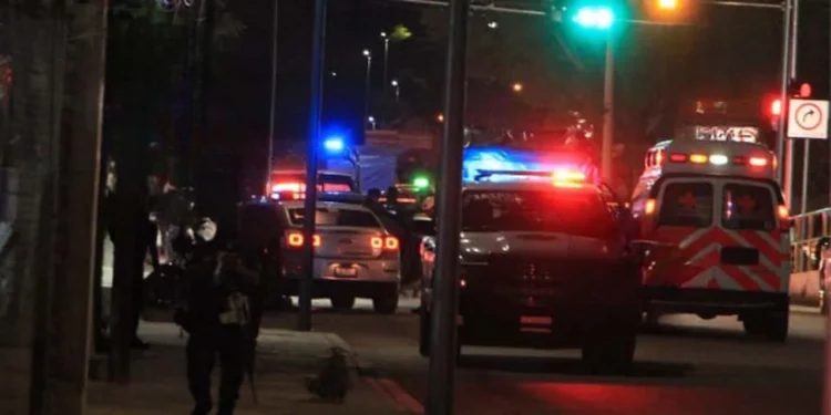 Peritos de la Fiscalía General de Oaxaca recolectan decenas de casquillos percutidos sobre el asfalto tras la violenta emboscada en el crucero de San Juan Bosco.