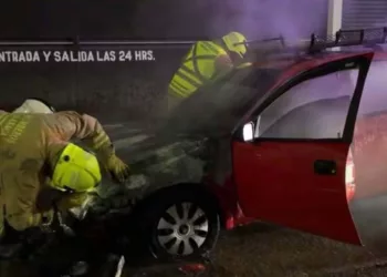 Personal de la Estación Oriente de Bomberos sofocó el fuego en el compartimiento del motor del Chevy rojo.