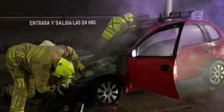 Personal de la Estación Oriente de Bomberos sofocó el fuego en el compartimiento del motor del Chevy rojo.