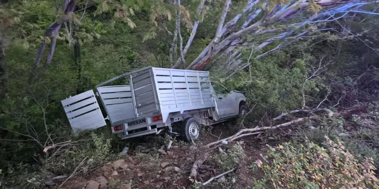 La camioneta Nissan de redilas terminó volcada sobre su costado izquierdo tras el violento impacto ocurrido en la carretera federal 190.