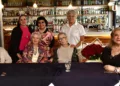 Las cumpleañeras Cristina Larumbe Rosado y Liz Ballesteros Reyes posan felices con sus ramos de rosas rojas.