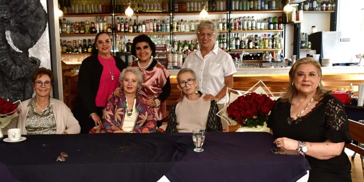Las cumpleañeras Cristina Larumbe Rosado y Liz Ballesteros Reyes posan felices con sus ramos de rosas rojas.