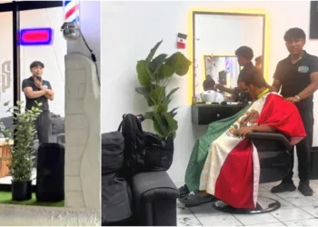 Peluquero en Puerto Escondido usa la bandera como capa para cortar el pelo